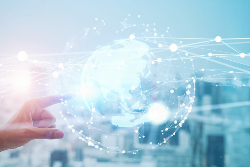 ネットワークでつながる地球を指差す手